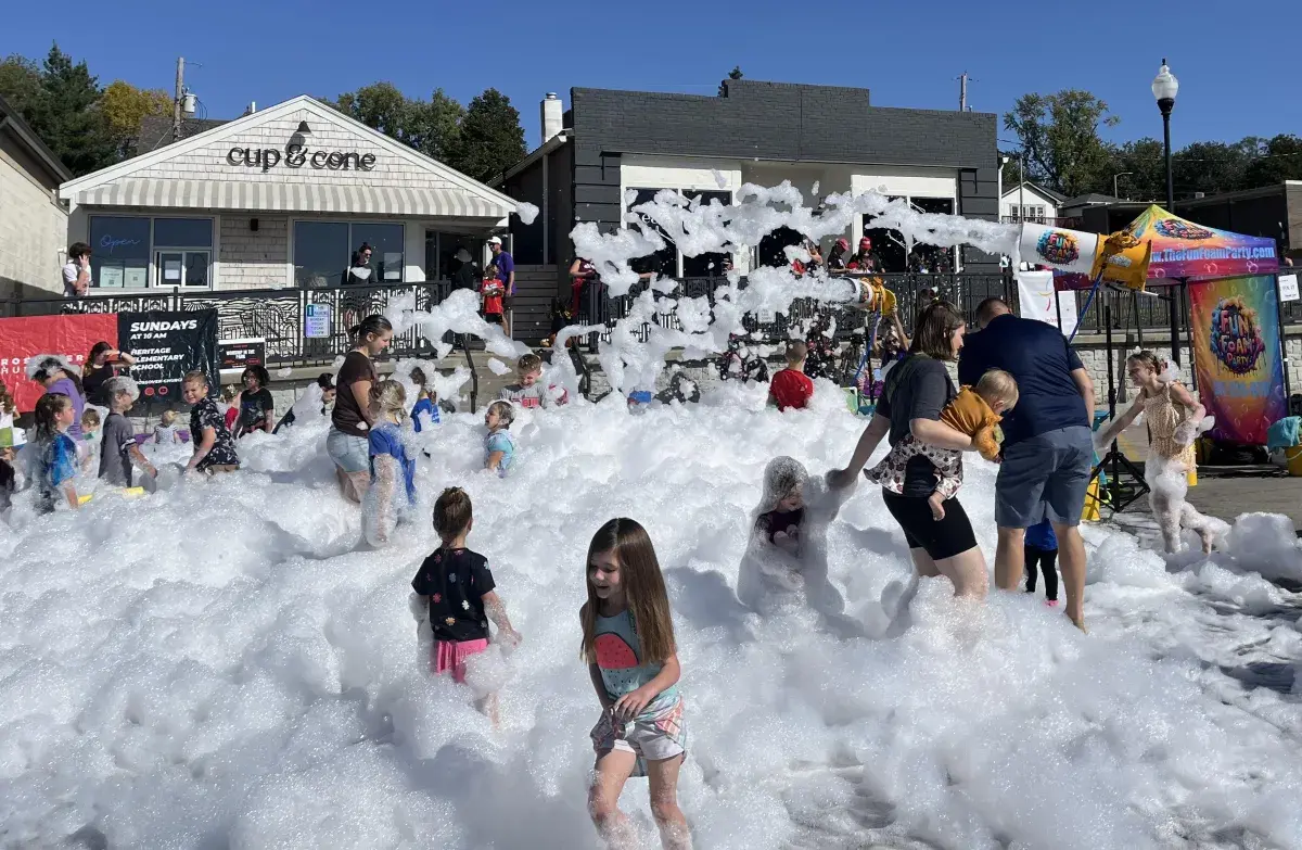 Children playing in a 1-hour foam party outside