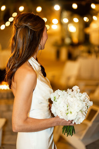 Bride dressed in wedding gown smiling at her reception.