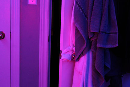 a photo with pink and purple lighting of a slightly open door