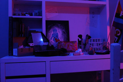 A photo of a desk covered with make up with blue and purple lighting