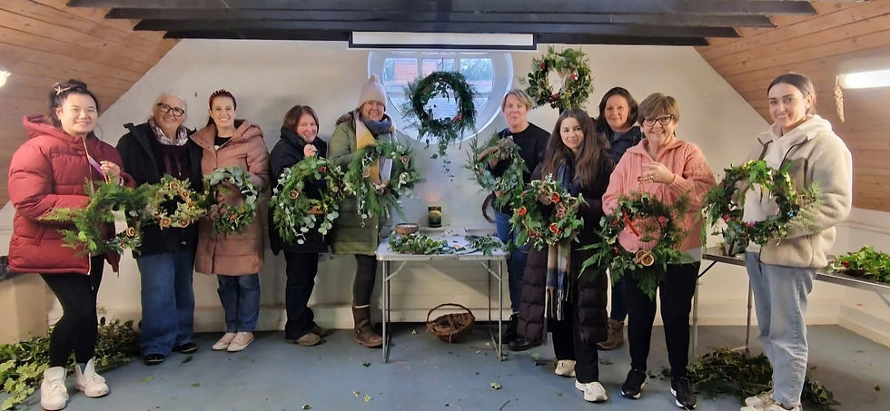 group of women holding up their christmas wreaths