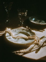 notprey_a_table_setting_but_the_food_is_a_pearl_necklace_drap_596ab28c-a3dd-43b9-b1d5-18d6
