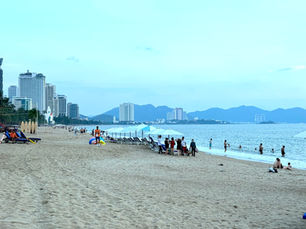 Relaxing evening at Nha Trang beach with locals, tourists, and coastal city views.