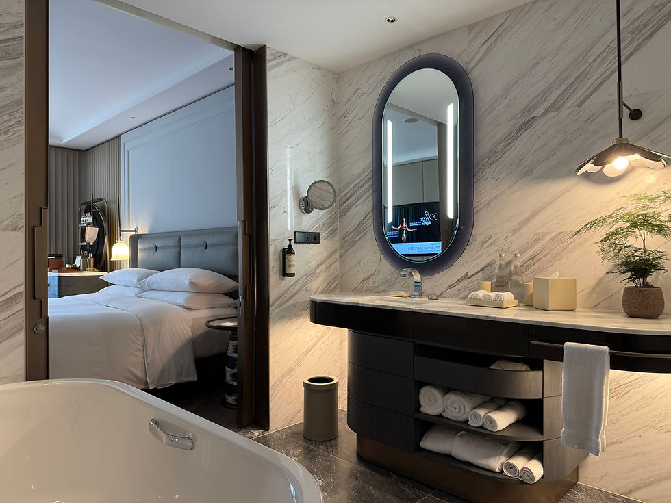 Marble bathroom with bathtub and vanity in a Fairmont King room at Fairmont Hanoi