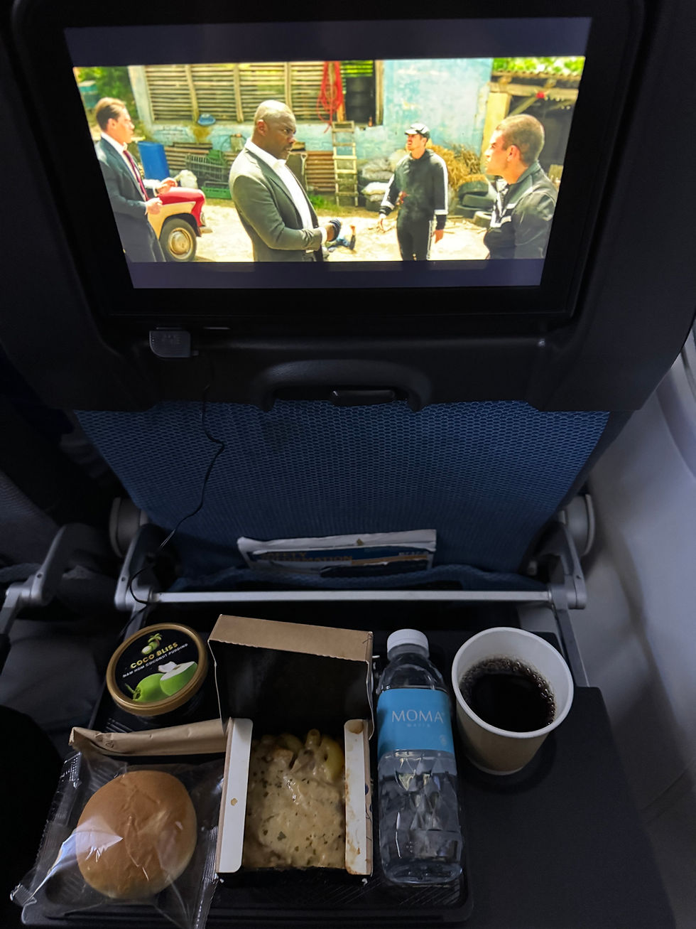 In-flight meal and entertainment screen on a Singapore to Bali flight in economy class