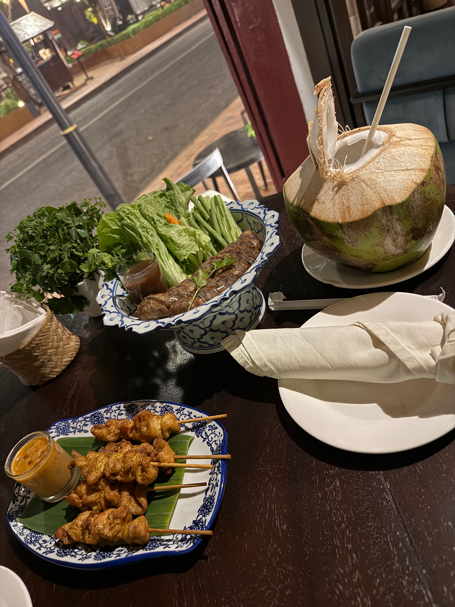 Lao sausage, chicken skewers, fresh vegetables and coconut water in Luang Prabang