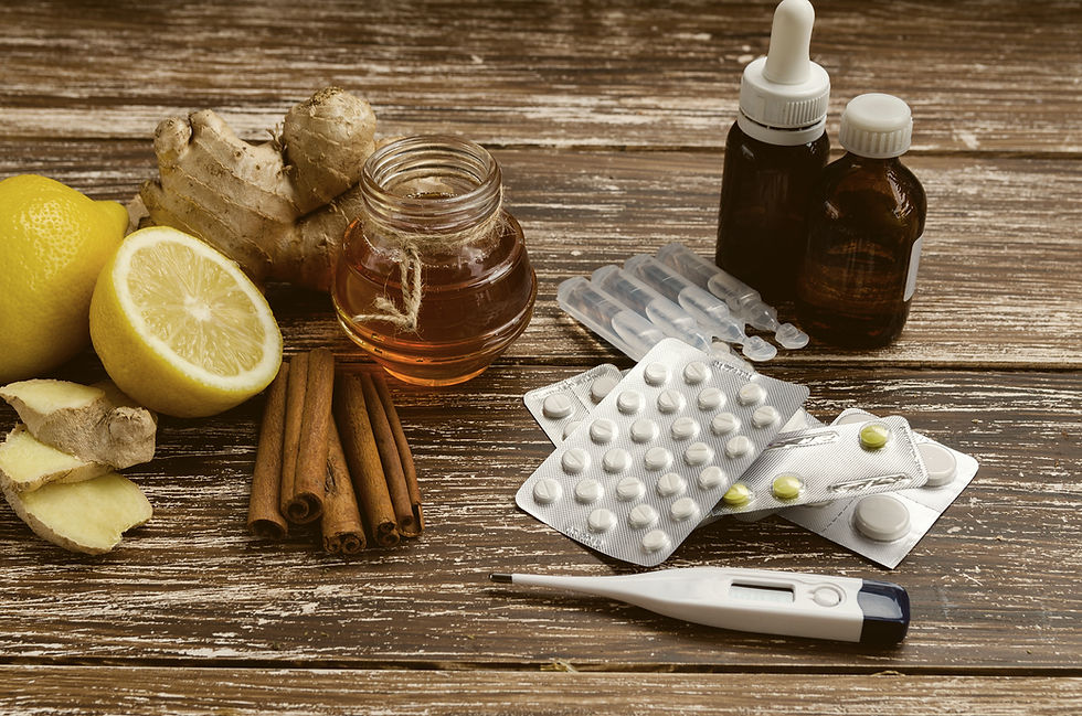 Ingwer, Zitrone, Honig und verschiedene Medikamente mit Thermometer auf hölzernem Hintergrund.Alternative Heilmittel und traditionelle Tabletten zur Behandlung von Erkältungen und Grippe. Naturmedizin gegen konventionelle Medizin