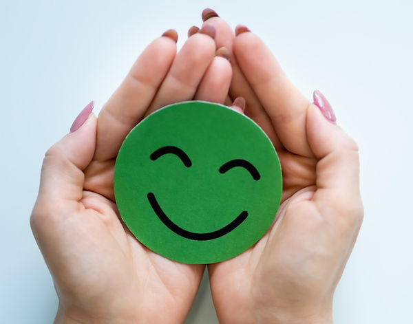 An accent image of cupped caucasian hands holding a green circle smiley face
