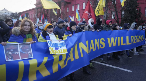 People standing in a line, holding a poster that reads, Ukrainians will resist