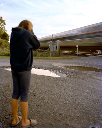 kid holding their ears as the train goes by on the hudson river in tivoli ny photograph by Megan Reilly for A Deal with God photography book