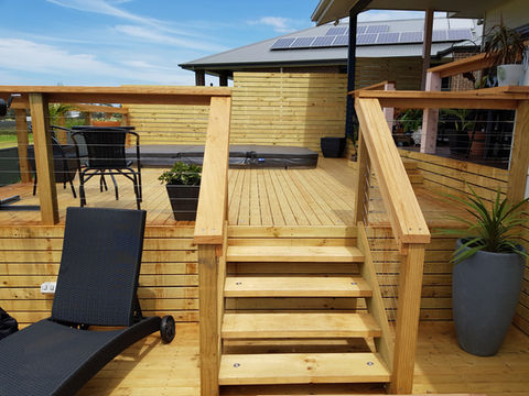 Wooden deck with stairs, handrails, and outdoor furniture.