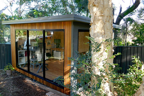 Modern backyard office pod with large glass windows.