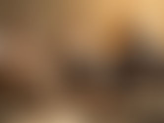 A same-sex couple in divorce mediation with a female mediator, reviewing a parenting plan together in a calm, sunlit office.