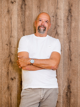 Oliver Rendel, Business Coach, Linz — Portrait vor Holzwand