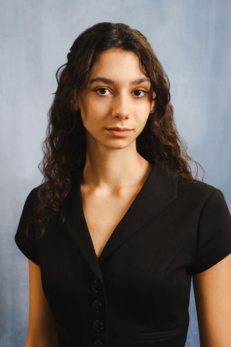 Professional headshot of a woman wearing a black top, photographed against a soft neutral backdrop. A clean, modern portrait suitable for business profiles, company websites, and professional networking platforms.