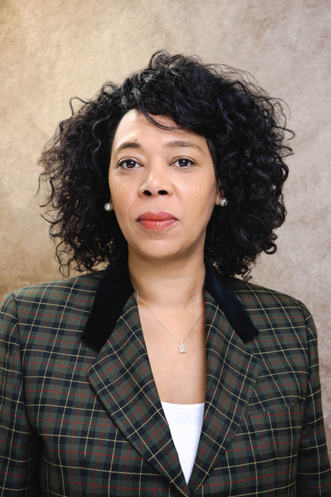 Business portrait of a woman wearing a patterned blazer, photographed against a warm-toned studio backdrop. A confident image suited for leadership roles, company profiles, and corporate communications, shot in Central London.