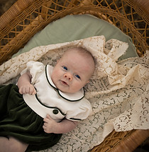 A baby in a vintage cradle looking up