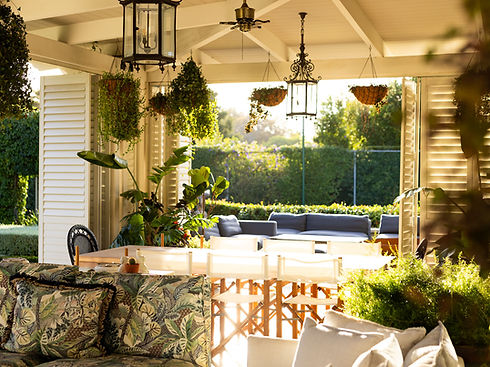 Sunlit tropical covered patio with louvered shutters