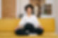 A pregnant woman meditates on a couch