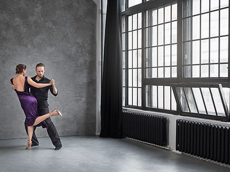 Two people dance the tango in a studio