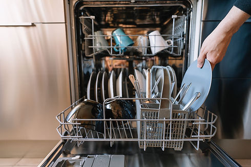 A homeowner loading a dishwasher