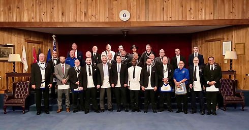27 men of diverse ages and races in business attire stand in the Freemason Lodge in Naples, FL