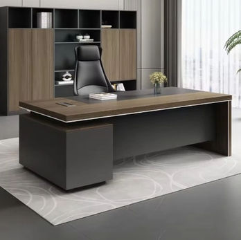 A black leather full-backed chair behind a modern, large slate and brown desk