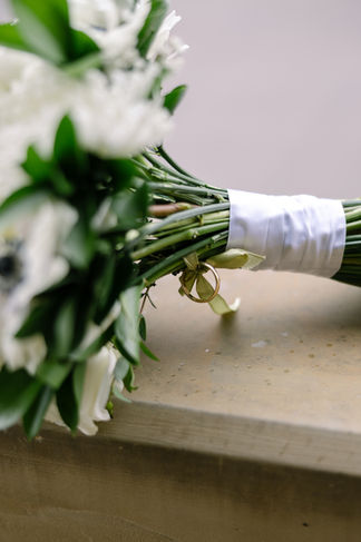 Close-up of white rose bridal bouquet wrapped in satin ribbon for Edmonton wedding.