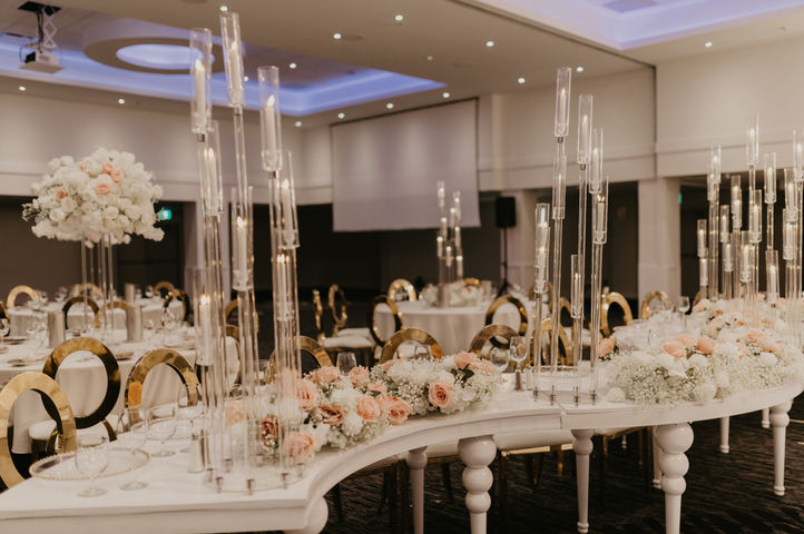 Wedding reception tables with floral centerpieces and candlelight in an elegant Edmonton venue.