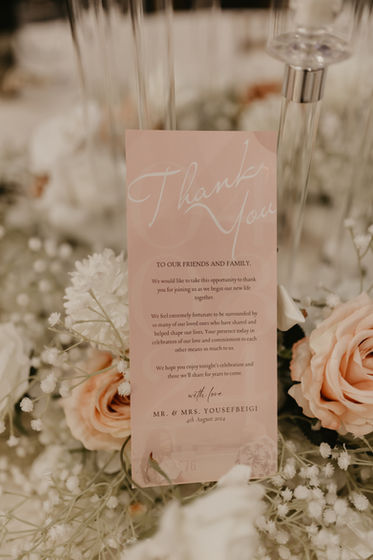 Custom printed wedding menu card with blush and gold accents on guest table.