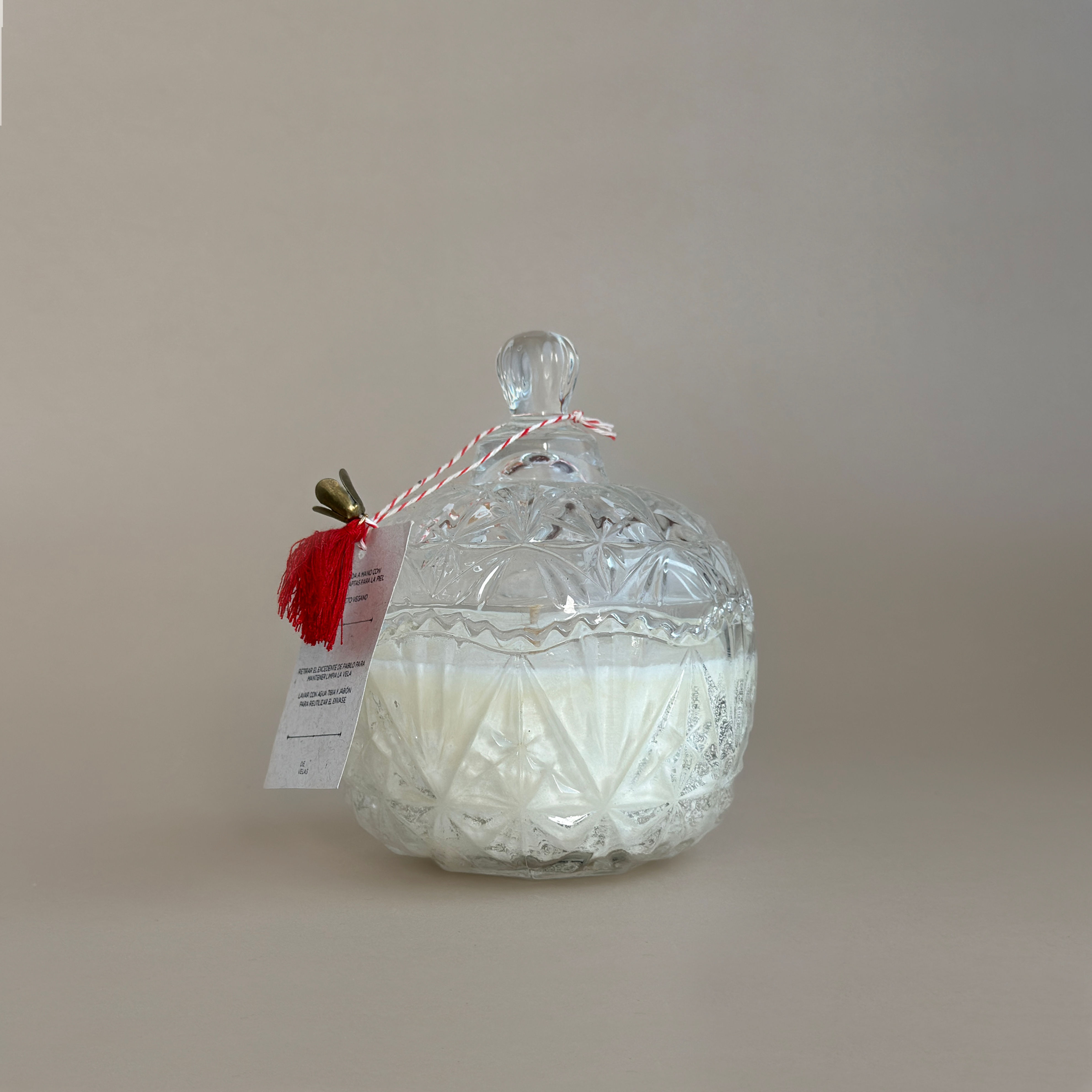 Bombonera de vidrio antigua con vela aromática encendida decorando un tocador o mesa vintage