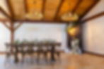 The elegant interior of the barn featuring stone floors and a wood accent wall and detailed ceiling