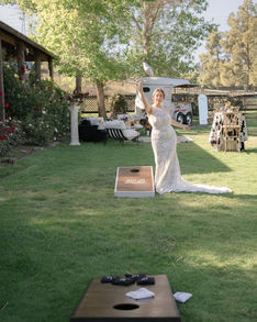 bride plays games during the cocktail hour in the pasture of slo wedding venue