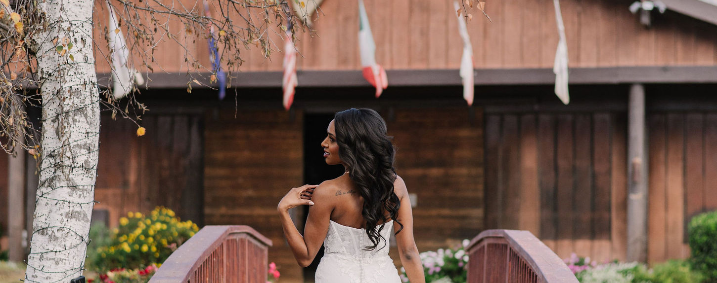 bride walks over a rustic bride towards the gardens at our slo wedding venue