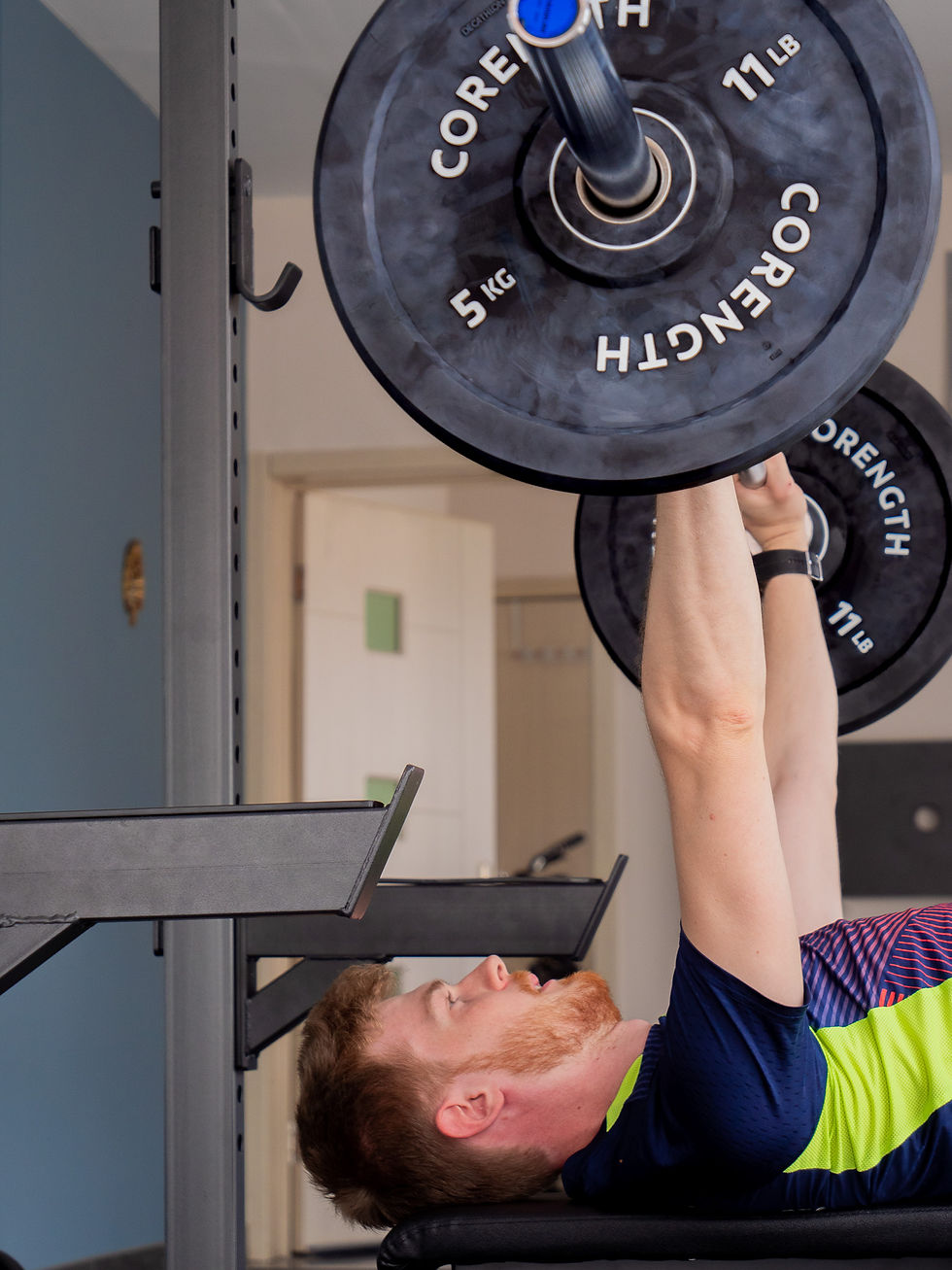 Martijn duwt een barbell op