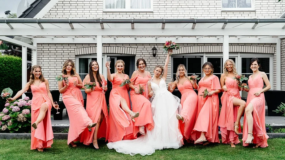 Das Foto zeigt posierende Brautjungfern in rosa Kleidern.
