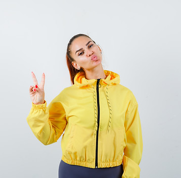portrait-young-lady-showing-peace-gesture-pouting-lips-tracksuit-looking-confident-front-v