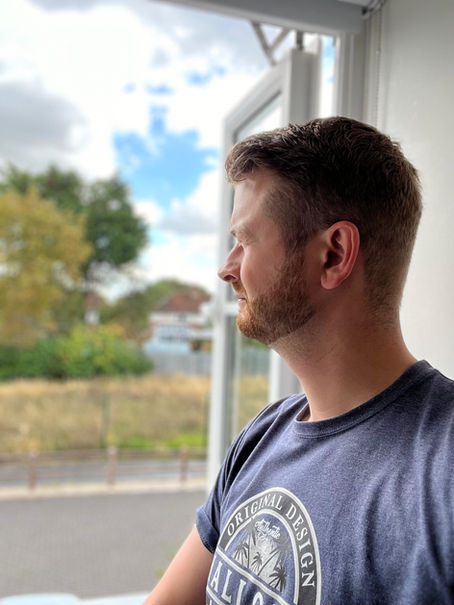 Michael Ling, ADHD Coach staring out of a window while reflecting