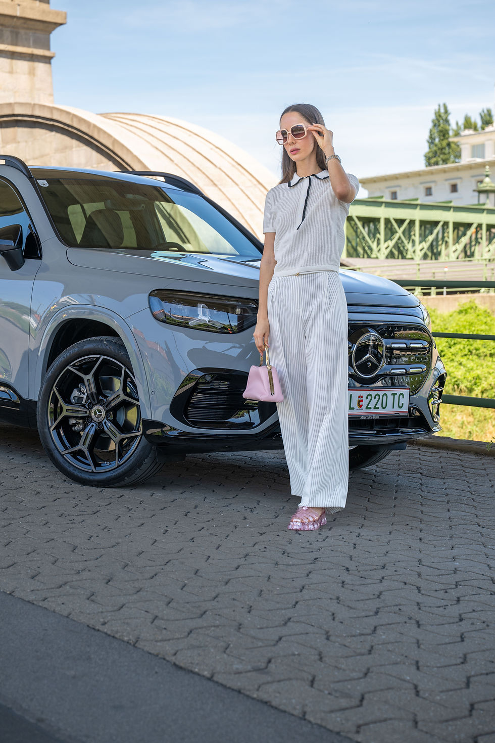 Model in Sommermode vor Mercedes GLB