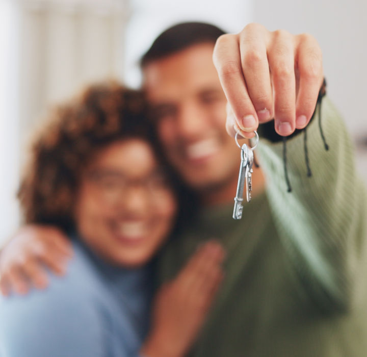 Couple heureux recevant les clés de leur nouveau logement après la réalisation des diagnostics immobiliers obligatoires par Prestimmo.