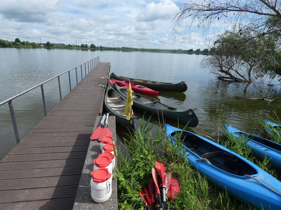 Kanus und Kajaks am Steg an einem ruhigen See