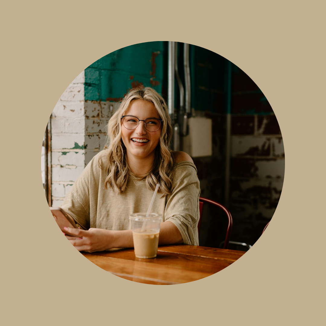 A woman sitting in a cafe with an iced coffee