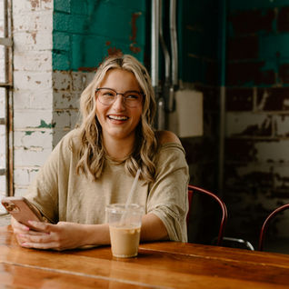 A woman enjoying an iced coffee in a coffee shop