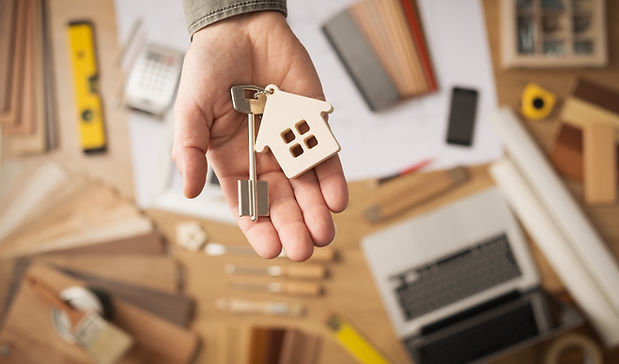 Hand holding keys, keychain in the shape of a house