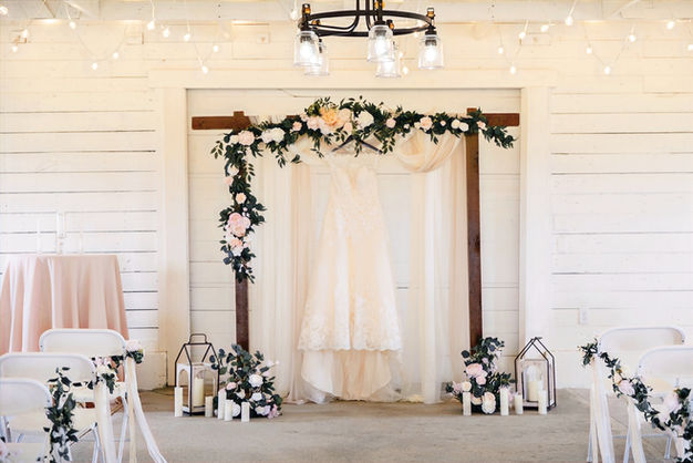 Indoor wedding ceremony arch with floral décor at Prosperity Event Venue in Argyle Texas.