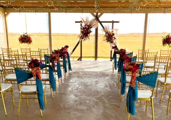 Outdoor wedding ceremony setup with floral arbor at Prosperity Event Venue in Argyle Texas.