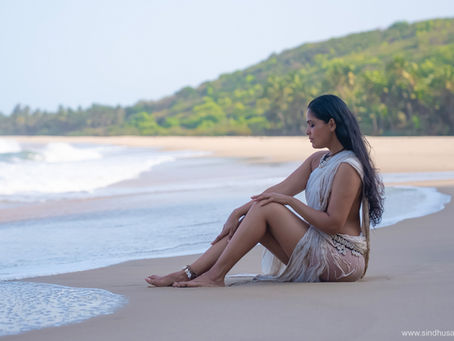 A conceptual shoot portraying the pure elemental beauty depicted in white. Sensual feminine form in the white fabric, white cowry jewellery , the white coral remains of the ocean, waves on the clean beach.