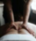a massage therapist working with both hands on a patients back