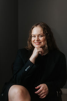 A woman posing for a headshot, with her chin resting on her hand