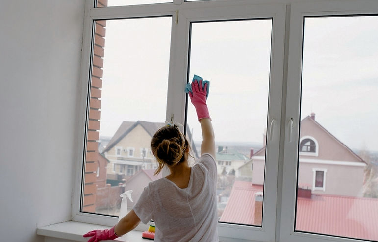 Fensterputzer reinigt Rahmen und Fensterbank einer Wohnung in Potsdam